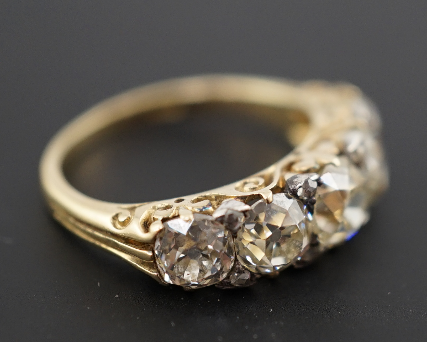 A Victorian 18ct and graduated five stone old round cut diamond set half hoop ring